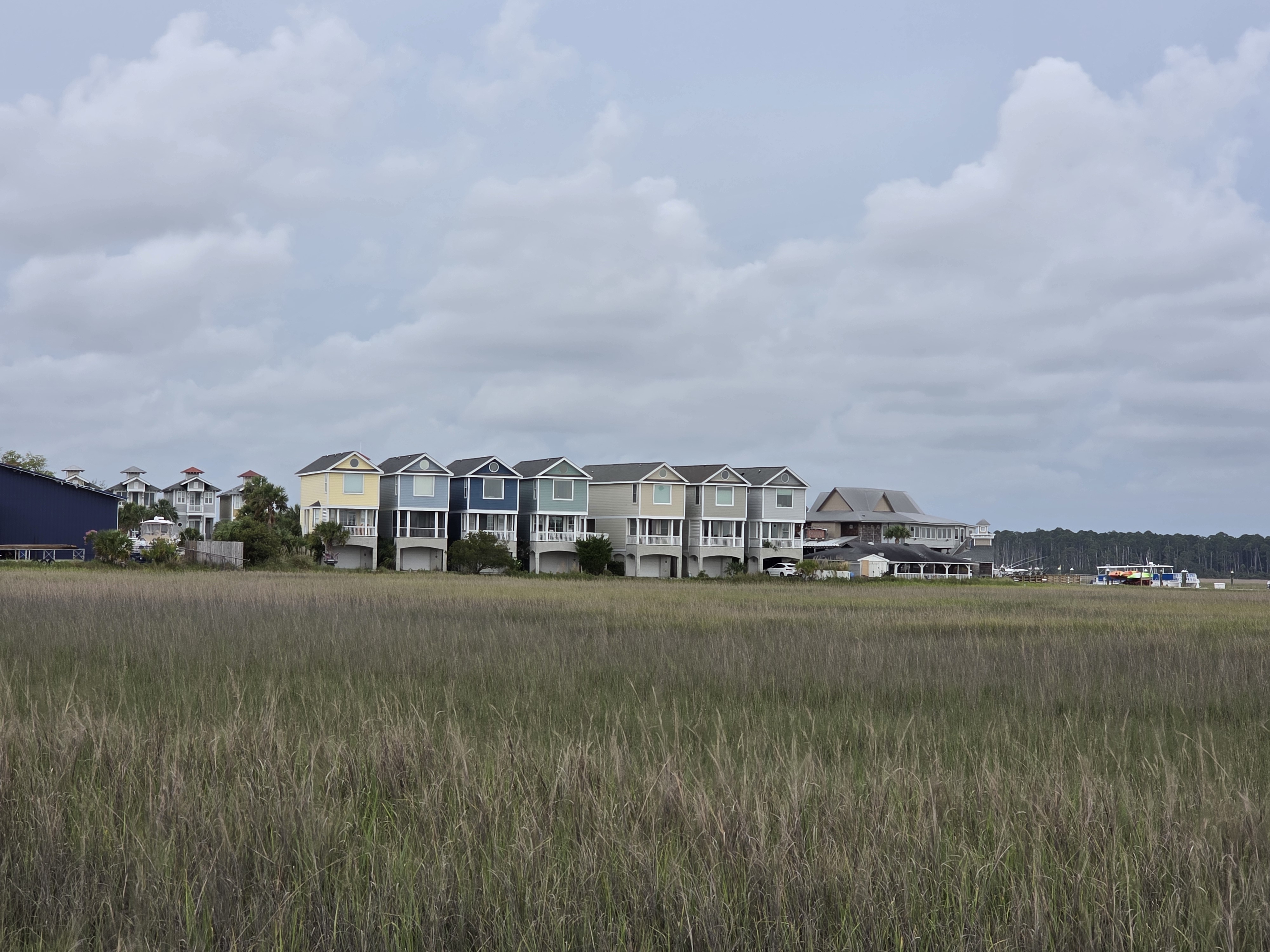 A cluster of colorful marina houses sitting on the marsh's edge.